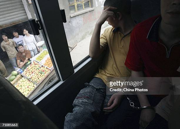 An inmate looks out of a coach during a prisoner transfer operation on May 30, 2006 in Chongqing Municipality, China. The mass prisoner transfer is...