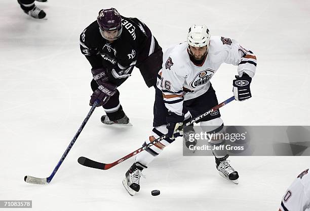 Jarret Stoll of the Edmonton Oilers looks to control the puck as Rob Niedermayer of the Mighty Ducks of Anaheim pursues the play during game five of...