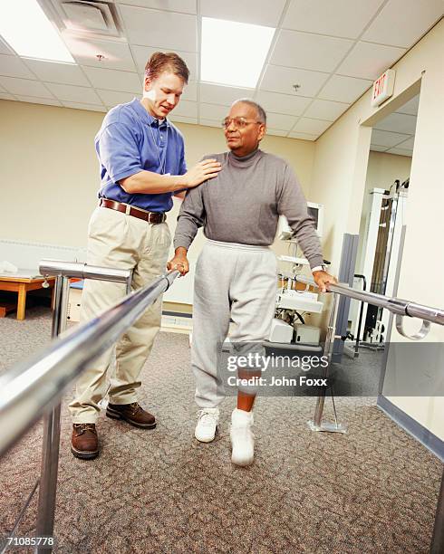senior man using bars to walk - parallel bars stock pictures, royalty-free photos & images