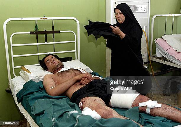 An Iraqi woman fans a wounded civilian at a local hospital in Baghdad 31 May 2006. The civilian was injured when a bomb exploded in a crowded popular...