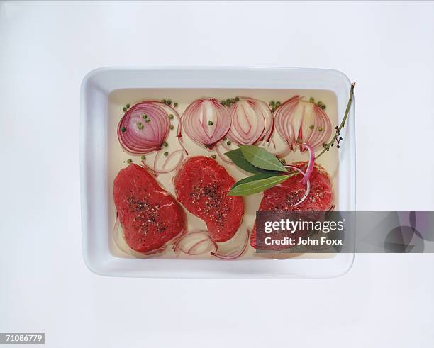 tenderloin with red onion filleted bay leaf in carton, directly above - filleted stock pictures, royalty-free photos & images