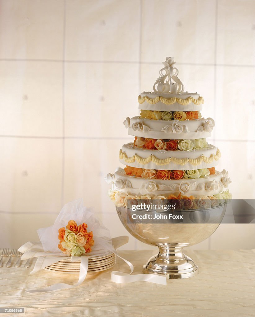 Wedding cake and stack of plates, close-up