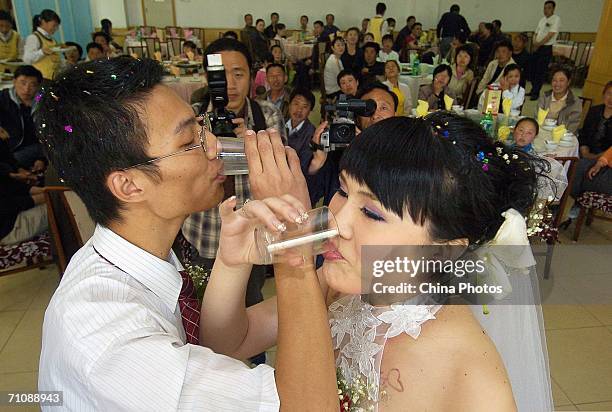 Transsexual Xinr and husband Huang Kunlun drink during their wedding reception on May 19, 2006 in Changchun, China. Once a man, 24-year-old Xinr...