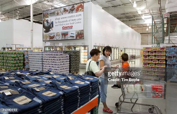 Shoppers pass a display of jeans in a Costco Wholesale store May 31, 2006 in Mount Prospect, Illinois. Third-quarter earnings reported today were up...