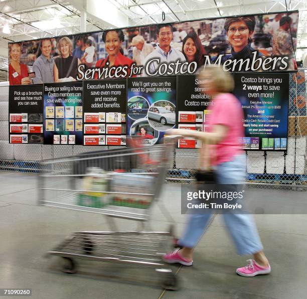 Shopper passes a sign describing the benefits of being a Costco member in a Costco Wholesale store May 31, 2006 in Mount Prospect, Illinois....
