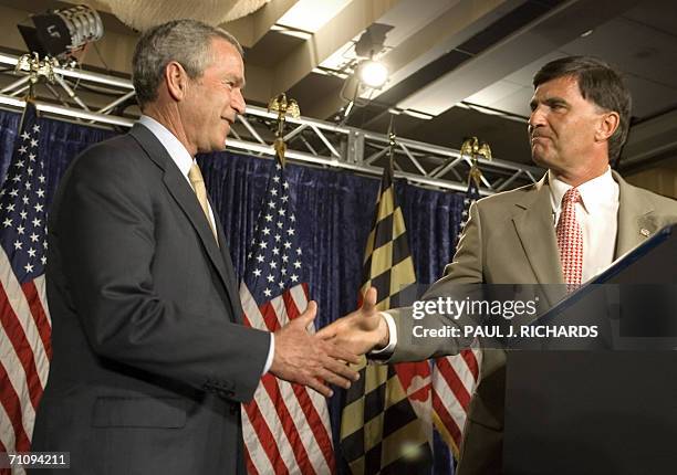 Baltimore, UNITED STATES: US President George W. Bush reaches out to shake hands with Maryland Governor Robert Ehrlich as they attend the Maryland...