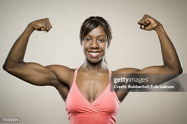 portrait of a young woman flexing her muscles - black female bodybuilder stock pictures, royalty-free photos & images