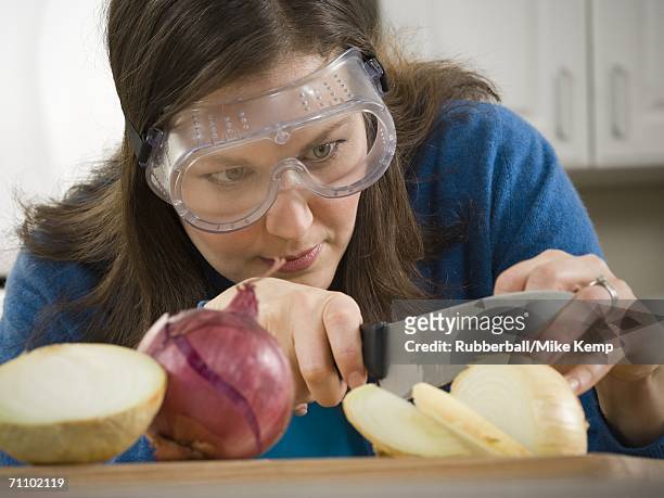 close-up of a mid adult woman cutting an onion - onion foto e immagini stock
