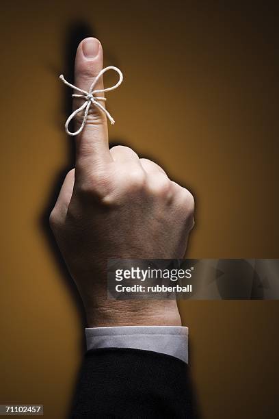 close-up of a string tied on a man's index finger - index finger fotografías e imágenes de stock