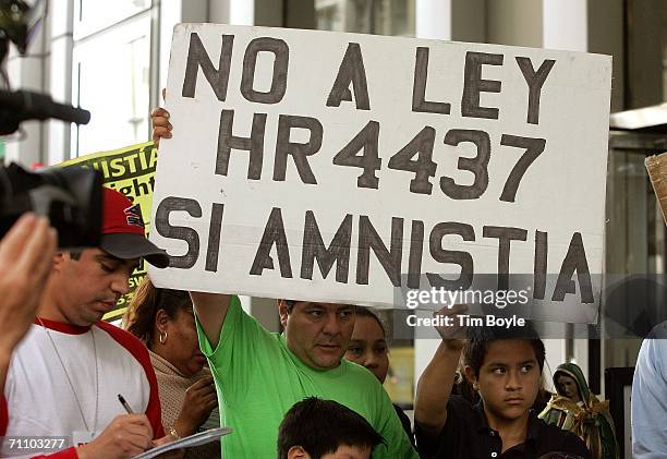 People hold a sign during a demonstration outside the federal Immigration Court June 1, 2006 in Chicago, Illinois. The rally was in support of 26...