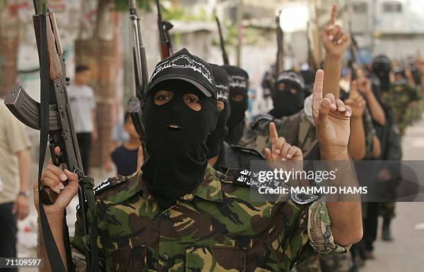 Militants from Al-Aqsa Martyrs Brigades, the armed wing of the Fatah movement, parade in the streets of the northern Gaza Strip refugee camp of...