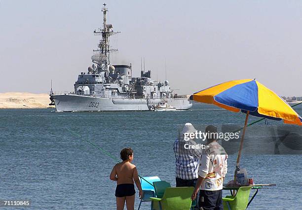 Egyptians cast their lines in the Suez Canal waters as the French guided missile destroyer Montcalm makes its way in front of the Egyptian port of...