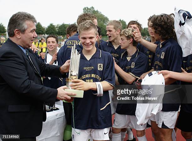 Peter Frymuth from the DFB gives the trophy to Florian Jungwirth of Munich after the B Juniors Championship Final between Borussia Dortmund and TSV...