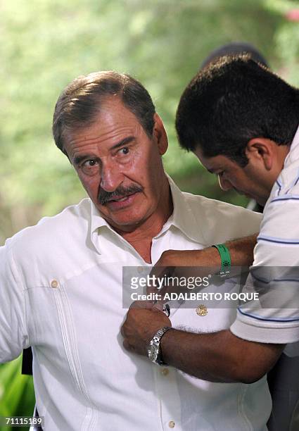 La Romana, DOMINICAN REPUBLIC: El presidente de Mexico, Vicente Fox espera a que le coloquen un microfono para una entrevista televisiva, el 03 de...