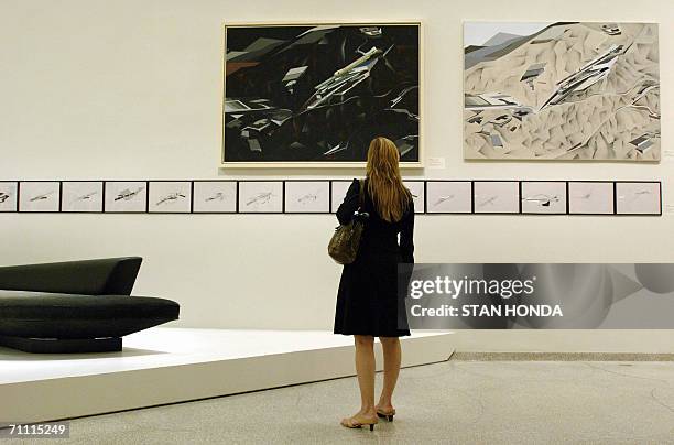 New York, UNITED STATES: TO GO WITH AFP STORY BY CATHERINE HOURS A woman views the retrospective of the work of Iraqi-born British architect Zaha...