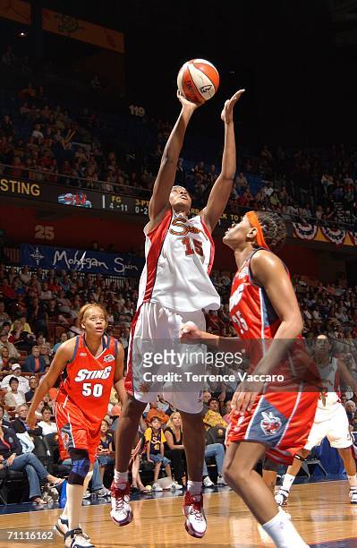 Asjha Jones of the Connecticut Sun goes to the basket against Monique Currie and Tangela Smith of the Charlotte Sting on June 3, 2006 at Mohegan Sun...