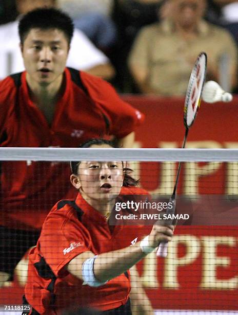 Chinese shuttler Zhonogbo Xie looks on as his teammate Yawen Zhangy returns the shuttlecock to their Indonesian opponents Nova Widianto and Liiyana...