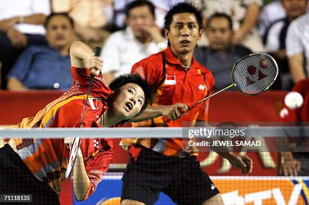 Indonesian shuttler Nova Widianto looks on as his partner Liiyana Natsir returns the shuttlecock to their Chinese opponents Zhonogbo Xie and Yawen...