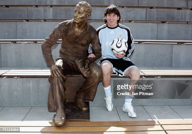 Lionel Messi of Argentina sits next to a statue of Adidas founder Adi Dassler at the World of Sports Stadium on June 4, 2006 in Herzogenaurach,...