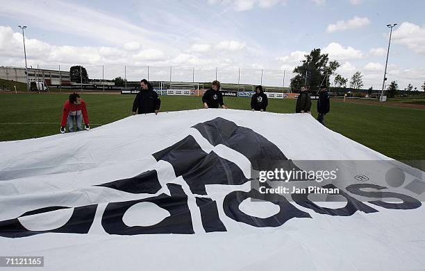Workers unfold a 60 by 15 metre big poster of Lionel Messi of Argentina at the World of Sports Stadium on June 4, 2006 in Herzogenaurach, Germany
