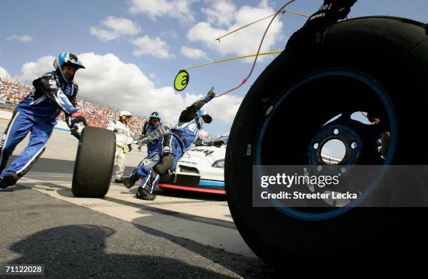 Crew members of the Alltel Dodge driven by Ryan Newman change tires on the car during a pit-stop during the NASCAR Nextel Cup Series Neighborhood...