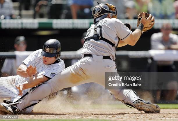 Matt Holliday of the Colorado Rockies fails to cross home plate ahead of the throw to catcher Matt Treanor of the Florida Marlins in the seventh...