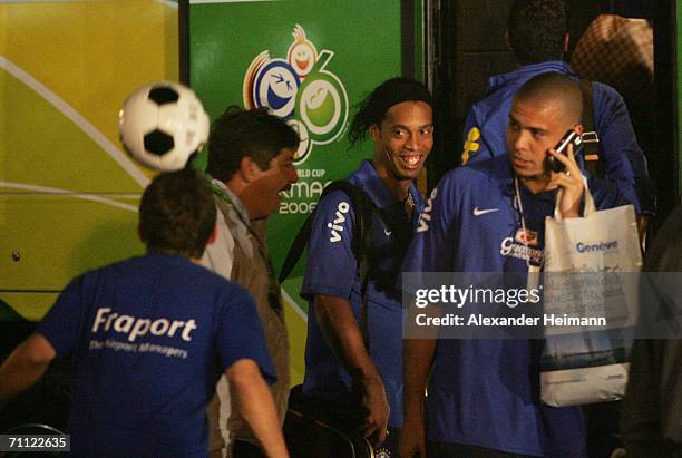 Ronaldinho and Ronaldo of Brazil watch a young boy as he performs some soccer tricks while they and other members of the Brazilian national football...