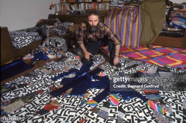 Portrait of Greek-born American sculptor, painter, photographer and performance artist Lucas Samaras as he sits on the floor amid a strips of fabric,...