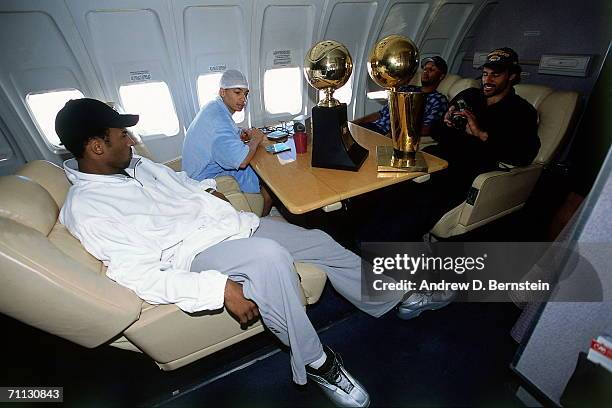 Kobe Bryant, Tyronn Lue, Rick Fox, and Brian Shaw of the Los Angeles Lakers chat on board the Lakers' team flight back to Los Angeles the day after...