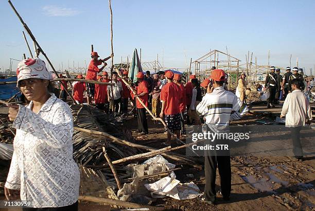 Members of the Cambodian police pull down structures at a slum during during the eviction of families in the Cambodian capital Phnom Penh, 06 June...