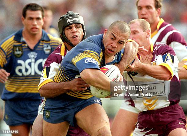 Jim Dymock of the Eels is tackled by Steve Renouf and Allan Langer of the Broncos during a NRL finals series match between the Brisbane Broncos and...