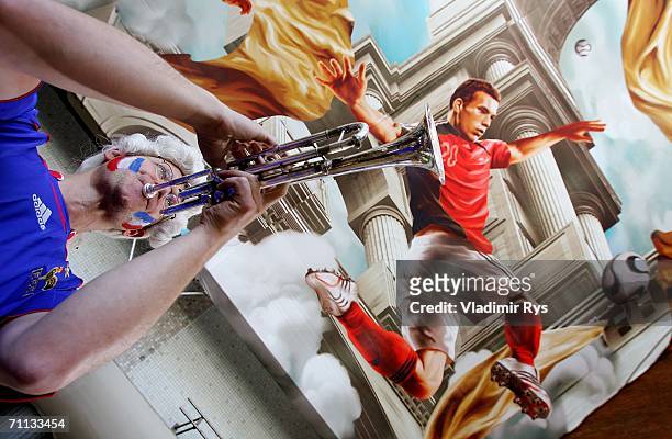 Ralph "Mosch" Himmler plays trumpet during the presentation of a huge 800 square meter world cup themed adidas poster at the entrance hall of the...