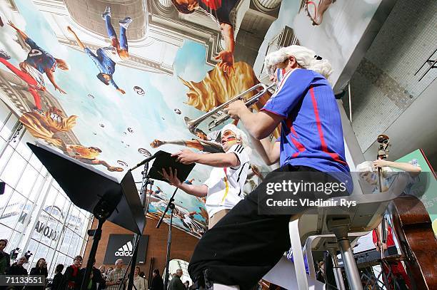 An orchestra plays music during the presentation of a huge 800 square meter World Cup Themed adidas poster at the entrance hall of the Cologne...