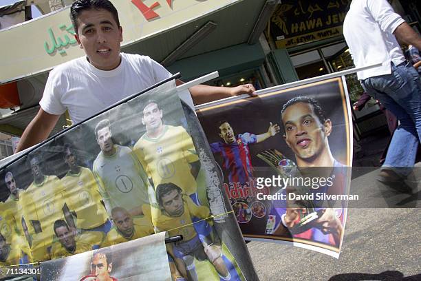 Palestinian vendor Ferras Rhade sells posters of the world's leading soccer players ahead of the World Cup June 6, 2006 in the West Bank town of...