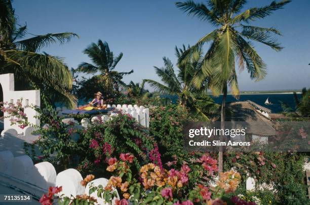 Emily Smith Myers lazes on a rooftop surrounded by bougainvillea on Lamu Island, in the Lamu Archipelago of Kenya, February 1987.