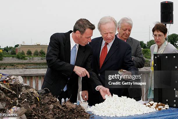 Glenn Rink, Founder and President of AbTech Industries, Inc., left, talks about a sample of polluted waste that was captured by Smart Sponge...