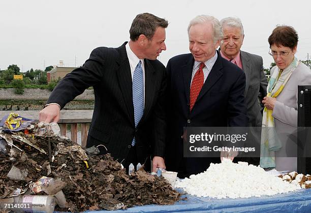 Glenn Rink, Founder and President of AbTech Industries, Inc., left, talks about a sample of polluted waste that was captured by Smart Sponge...