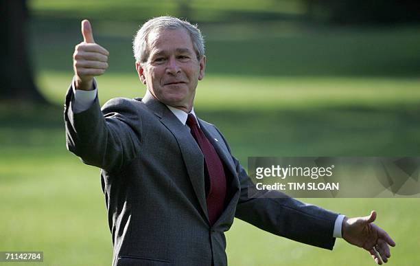 Washington, UNITED STATES: US President George W. Bush jokes with reporters as he walks to Marine One 06 June, 2006 on the South Lawn of the White...