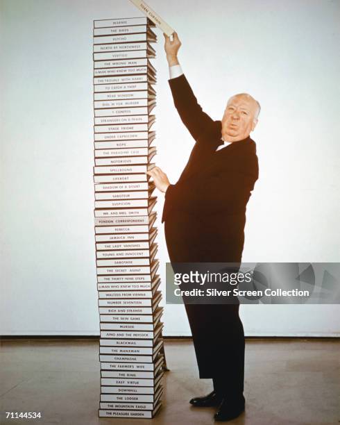 English film director Alfred Hitchcock adds the script of his latest film 'Torn Curtain' to a pile of scripts representing his career from 1925 to...