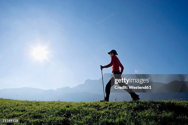 woman exercising nordic walking, austria, alps - mobility walker stock-fotos und bilder