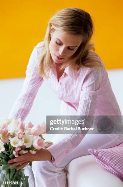 young woman arranging flowers in vase - barbel stock pictures, royalty-free photos & images