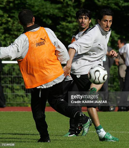 Saudi midfielder Nawaf al-Temyat fights for the ball with defender Abdulaziz Khathran and defender Hussein Sulimani a training session at Bad Nauheim...