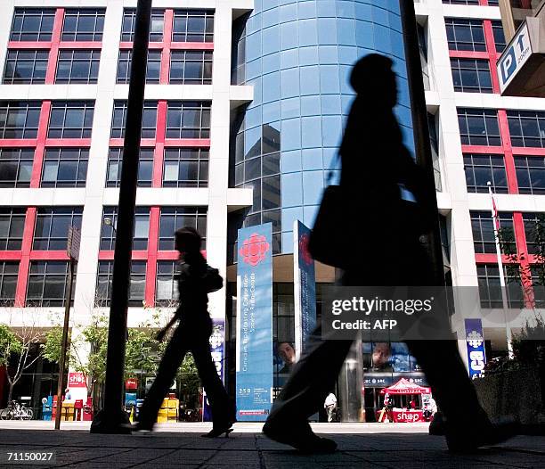 Pedestrians walk 07 June 2006 in front of the Canadian Broadcasting Corporation building in downtown Toronto which was reportedly one of the targets...