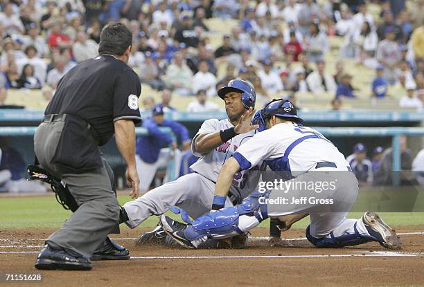 Julio Franco of the New York Mets slides into catcher Russell Martin of the Los Angeles Dodgers and is called safe by home plate umpire Rob Drake in...