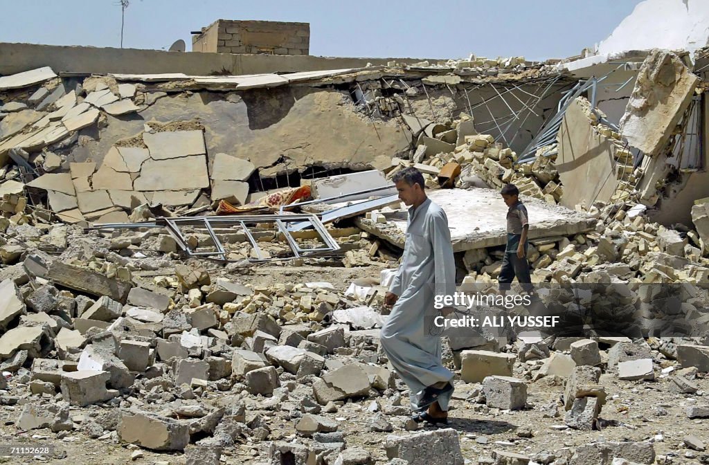 An Iraqi man walks 08 June 2006 in front