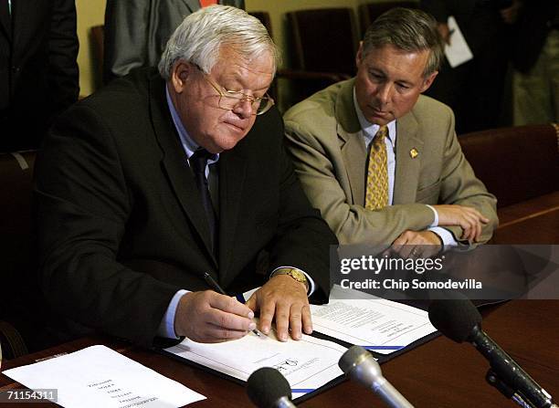 Speaker of the House of Representatives Dennis Hastert signs the "Broadcast Decency Enforcement Act," as one of the bill's sponsors, Rep. Fred Upton...