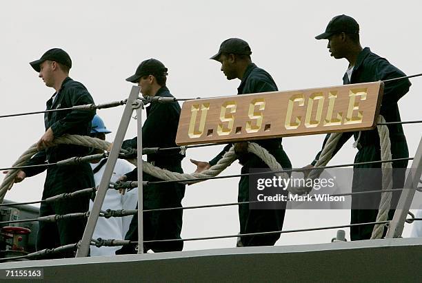 Navy Sailors pull in a line as the USS Cole prepares to depart the Norfolk Naval Station June 8, 2006 in Norfolk, Virginia. The Cole is departing for...