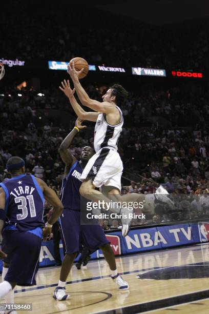 Manu Ginobili of the San Antonio Spurs drives to the basket against Jason Terry and DeSagana Diop of Dallas Mavericks in game seven of the Western...