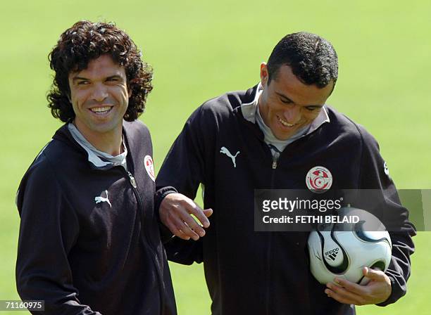 Tunisian team captain and midfielder Riadh Bouazizi and Tunisian midfielder Jawhar Mnari laugh during a training session at Saks Stadium in...