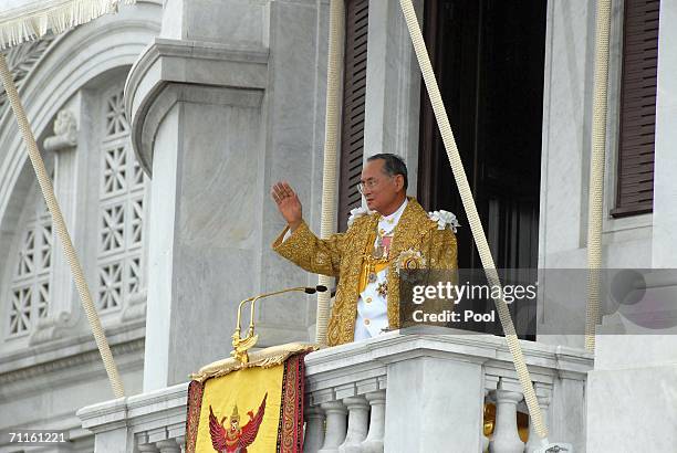 Thailand's King Bhumibol Adulyadej waves to the thousands of people waiting outside the Royal Plaza to pay tribute to King Bhumibol Adulyadej on June...